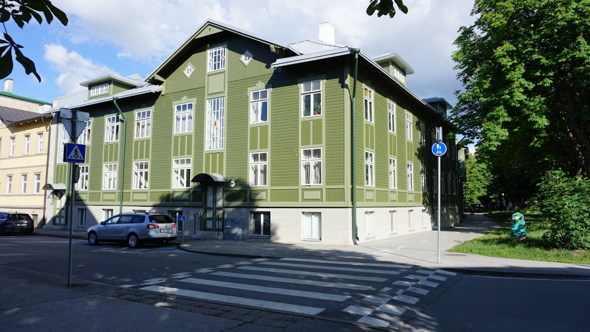 A large green building sitting on the side of a road